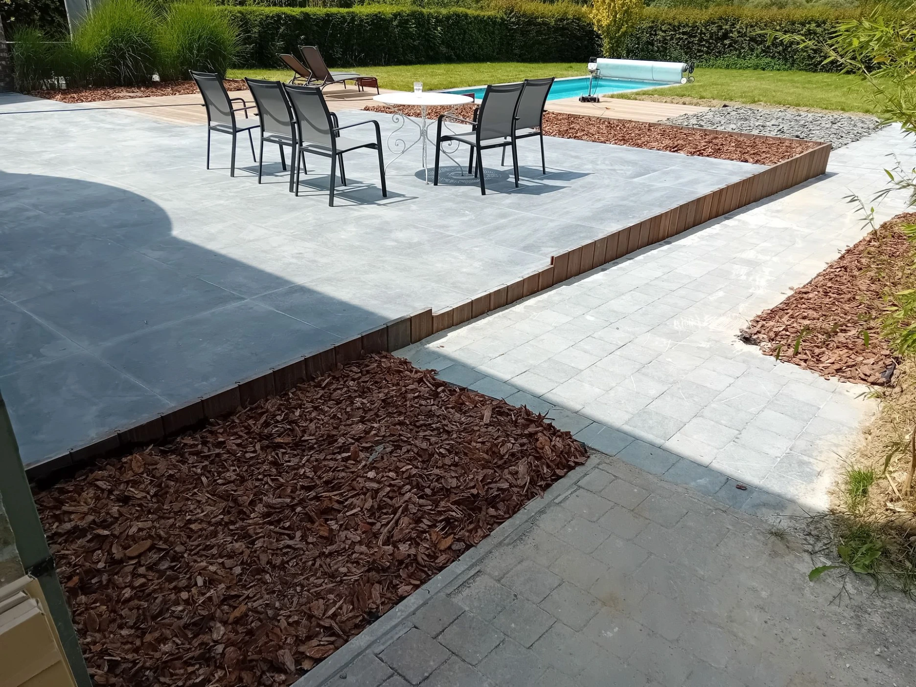 Terrasse carrelage autour d'une piscine avec allée en pierres bleues