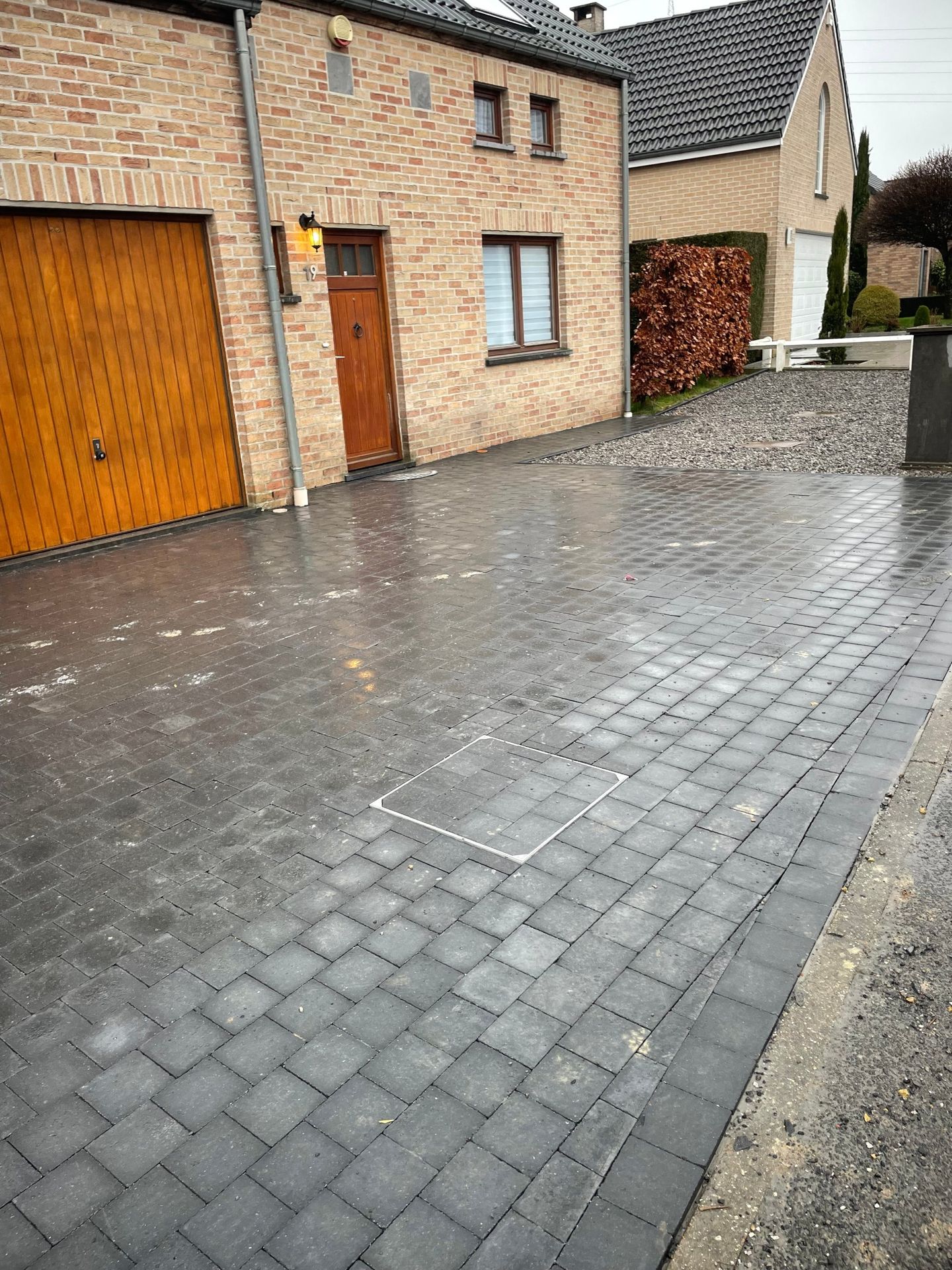 Entrée de garage en pavés béton noirs posée par Peaceingarden